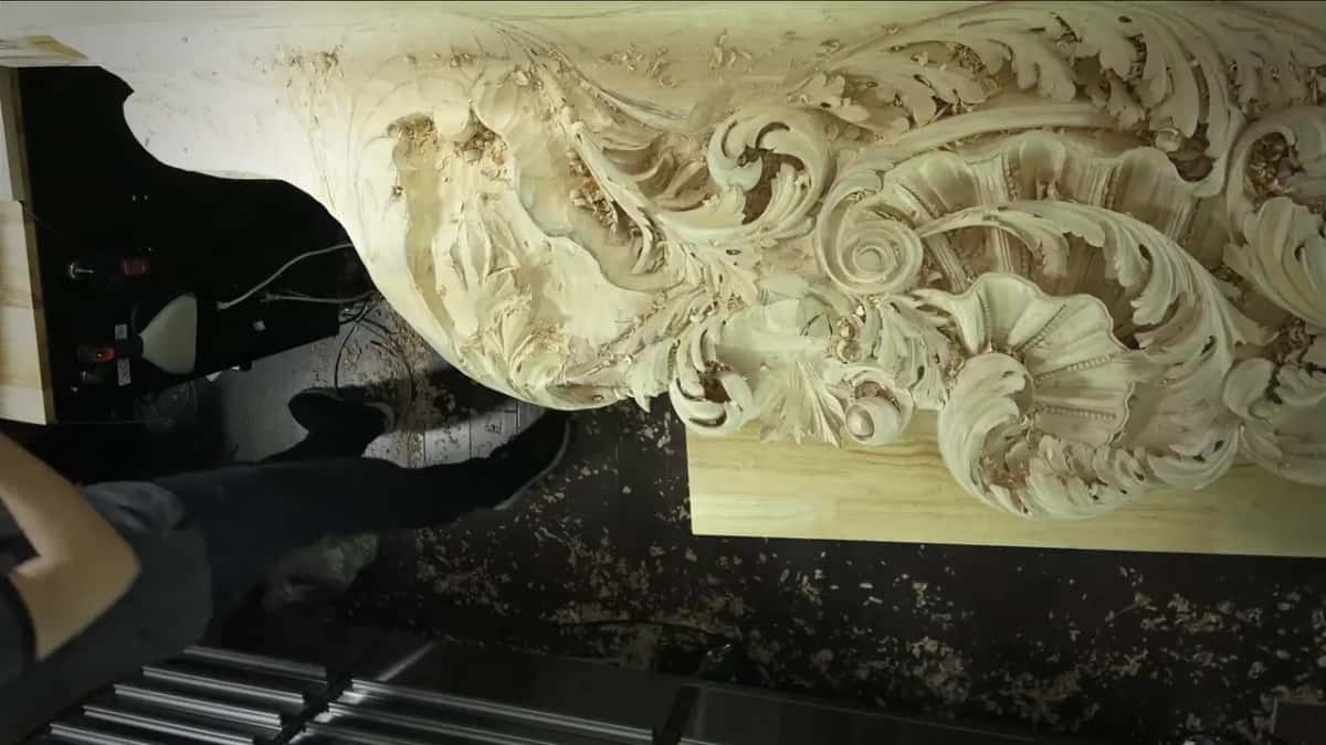 A large carved piece full of scrolls and deep hollows, seen from low down