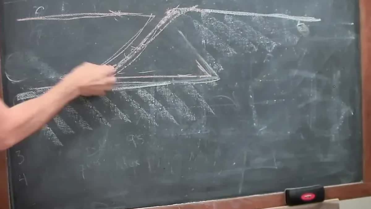Hand tracing a sloped wall in chalk