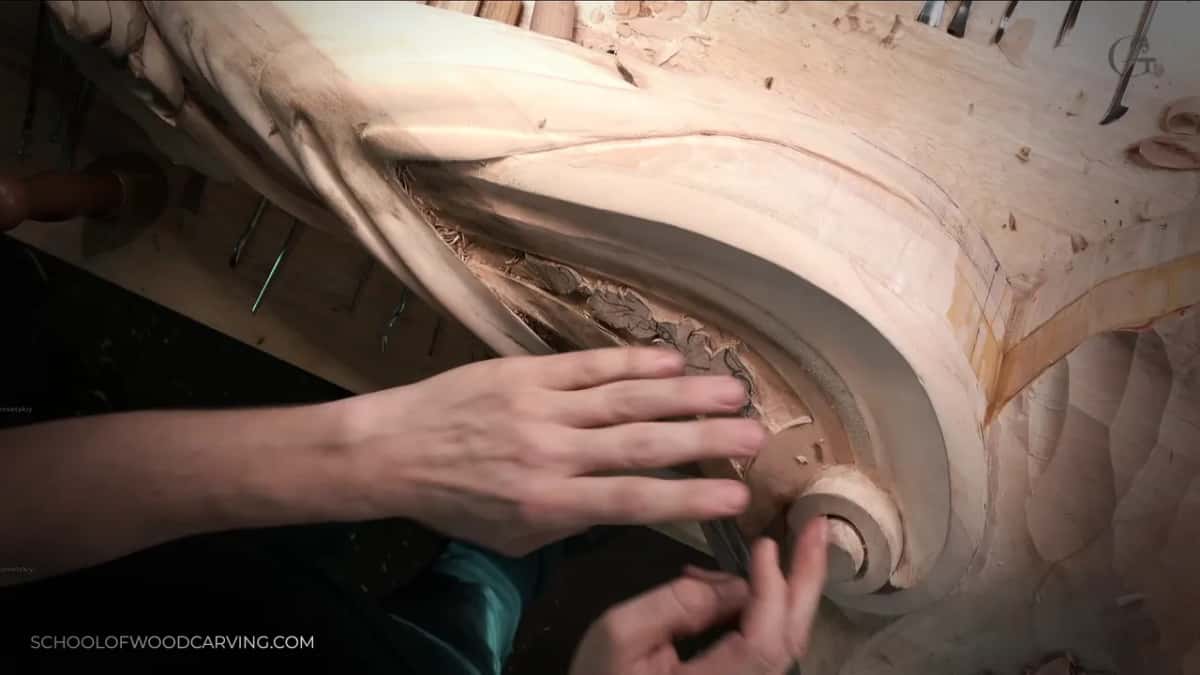 Both hands steady the scroll's volute