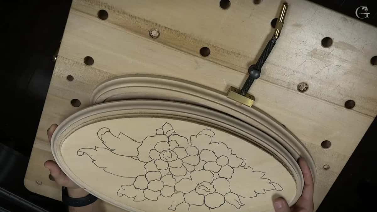Hands lifting the second blank, its flowers only drawn